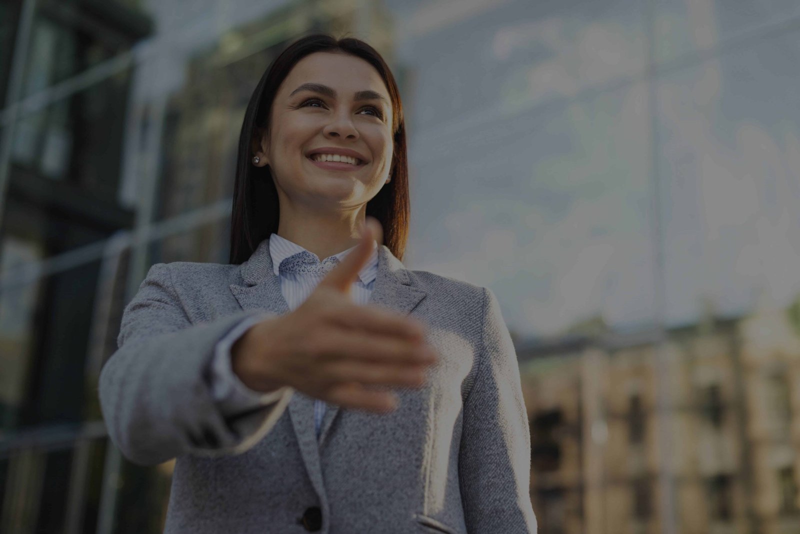 low-angle-smiley-businesswoman-giving-hand-handshake-outdoors (1)